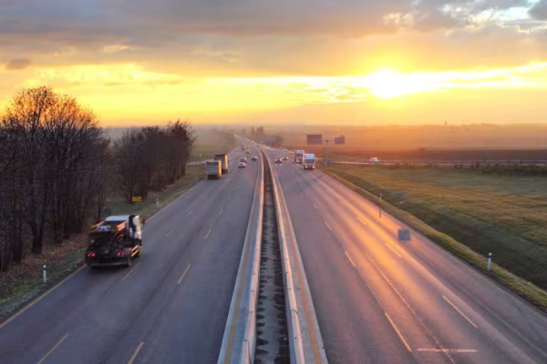 A dual carriageway with cars driving across