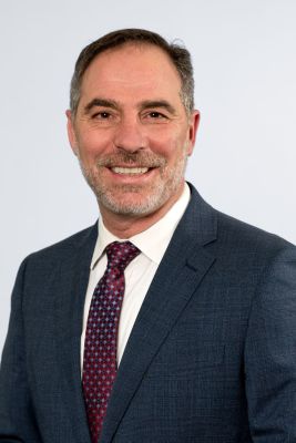 A headshot of Minister Jihad Dib in front of a white background